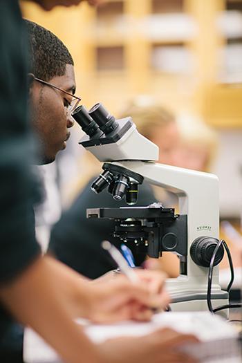 一个学生在看显微镜